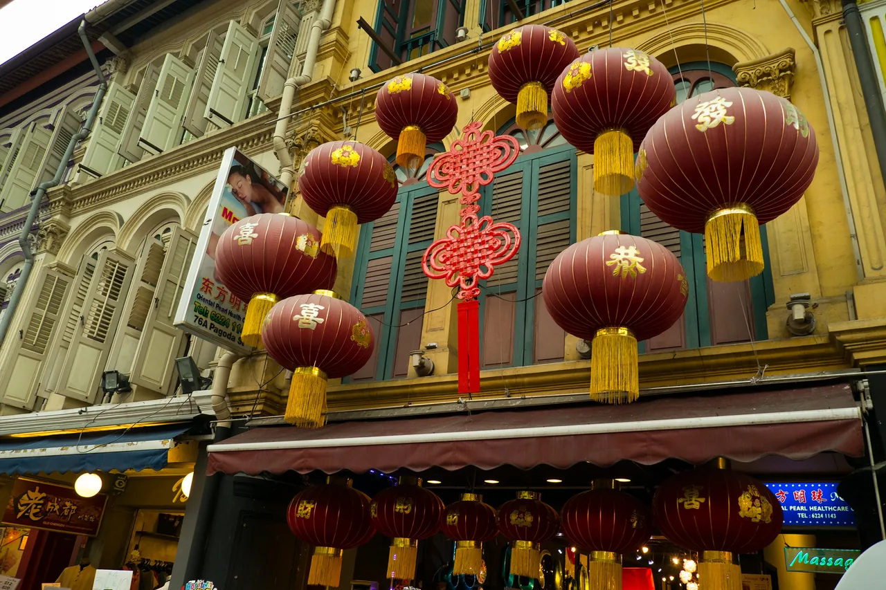 Red and gold Chinese lanterns strung across Pagoda Street beside shophouses in Singapore's Chinatown