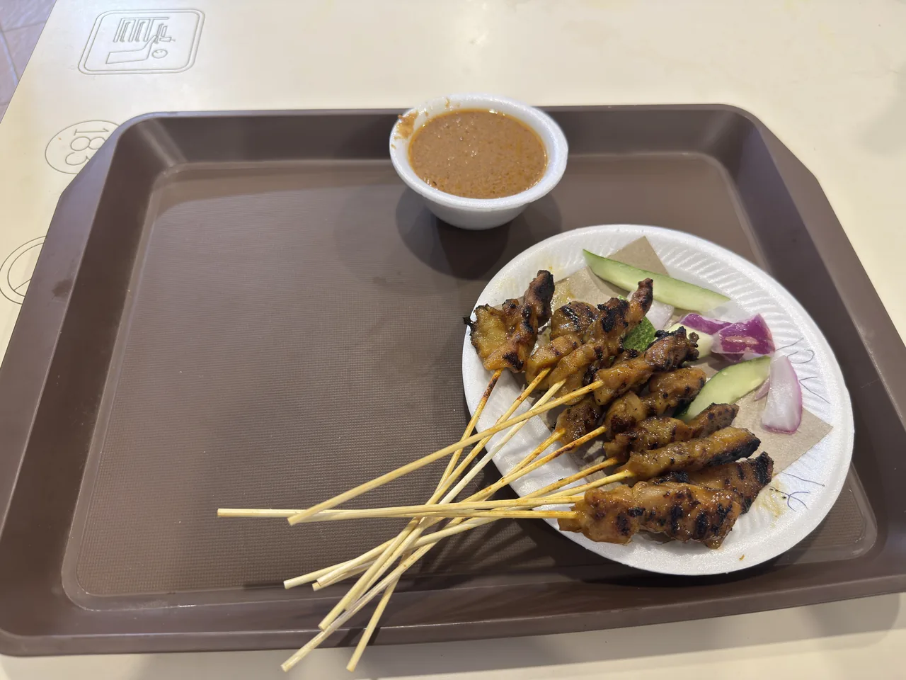 シンガポールのホーカー屋台で炭火焼きにされるサテーの串