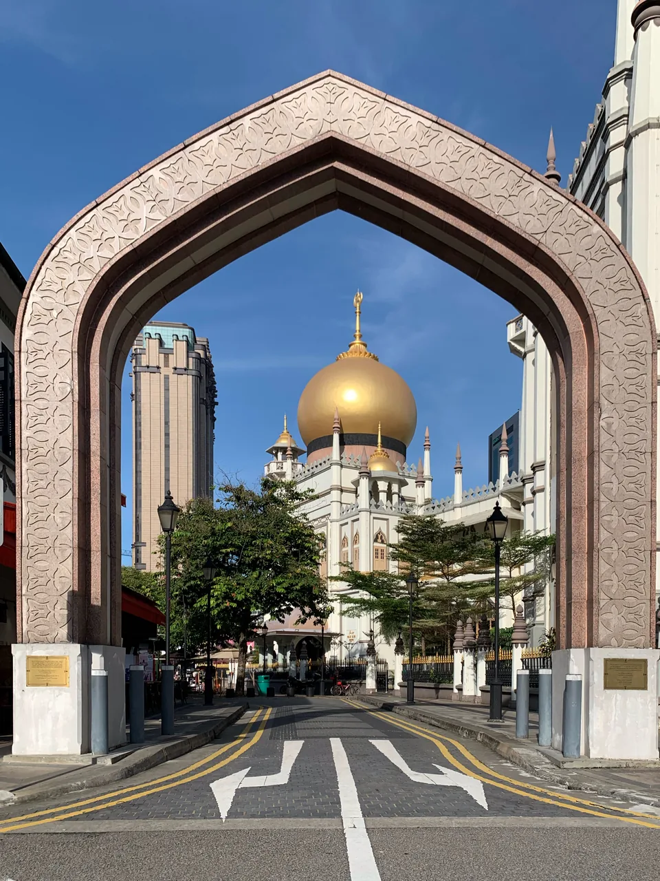 The golden dome of the Sultan Mosque framed by the decorative Muscat Street arch in Kampong Glam, Singapore