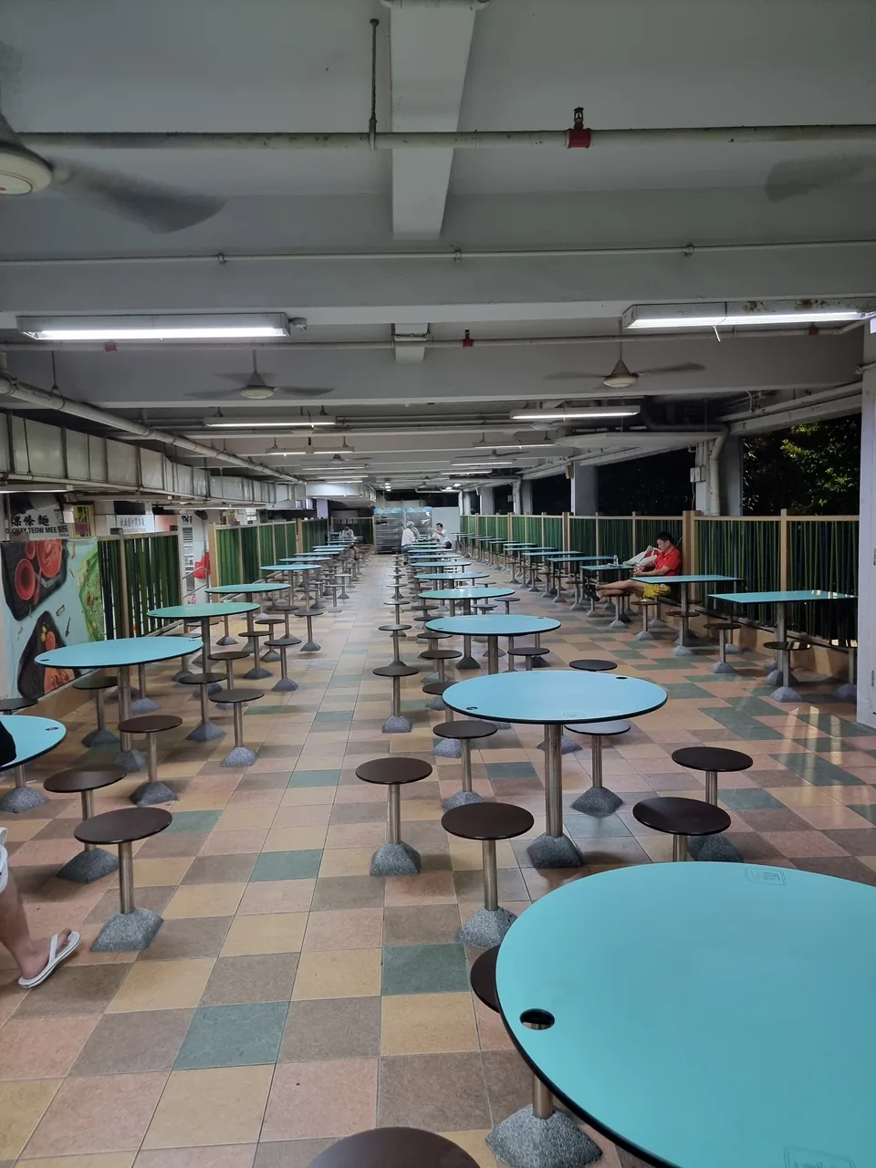 The seating hall of a hawker centre in Singapore with round tables and stools
