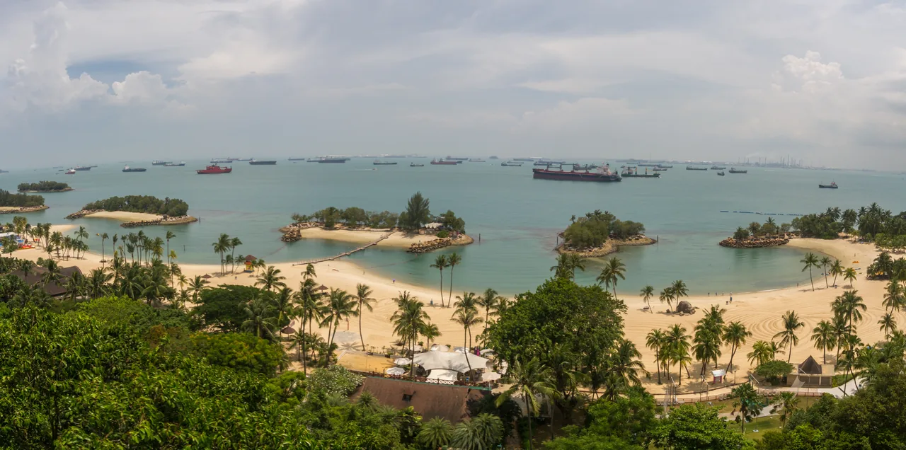 Panorama of Sentosa's beaches with cargo ships anchored on the horizon, seen from the Singapore Cable Car