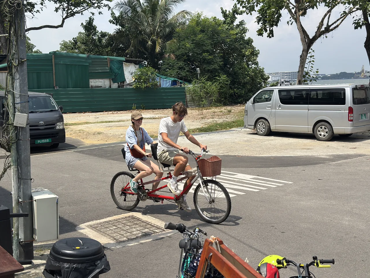 プラウ・ウビンの舗装路を走る二人乗り自転車の旅行者