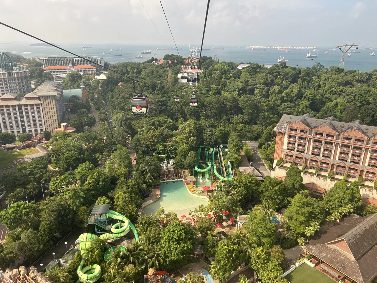 Adventure Cove Waterpark seen from a cable car cabin, with the wave pool and green water slides below