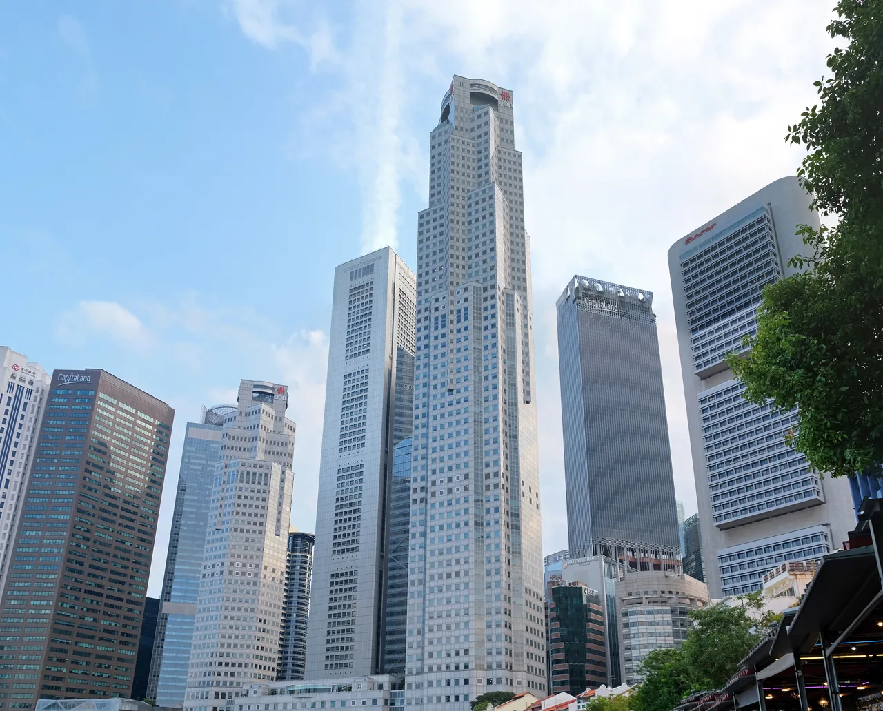 駁船碼頭。河的右側是搭著雨篷的店屋餐廳,緊挨其後就是金融區的高樓