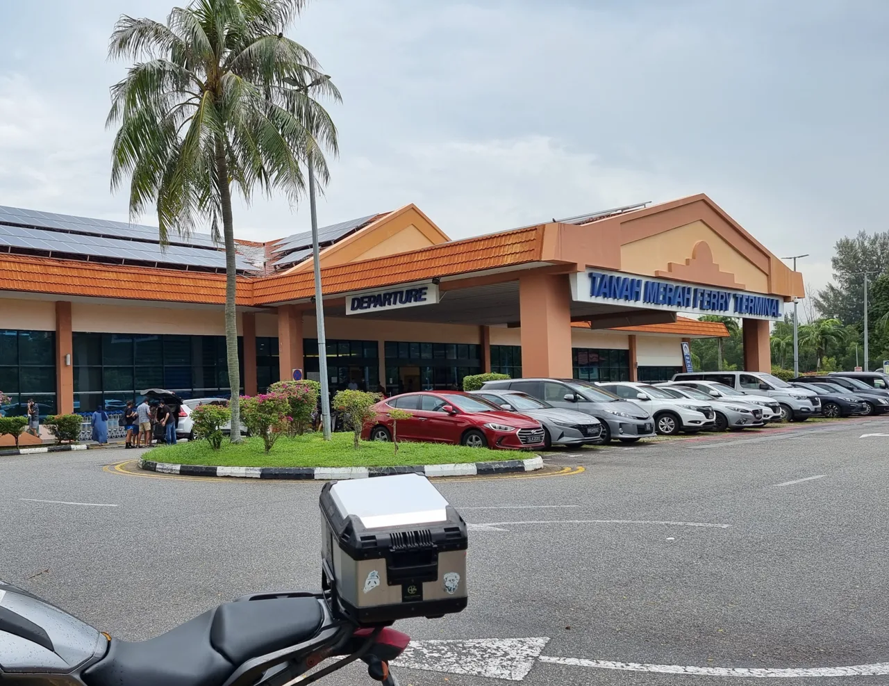 The Tanah Merah Ferry Terminal building in Singapore seen across the car park, with the departure sign above the entrance