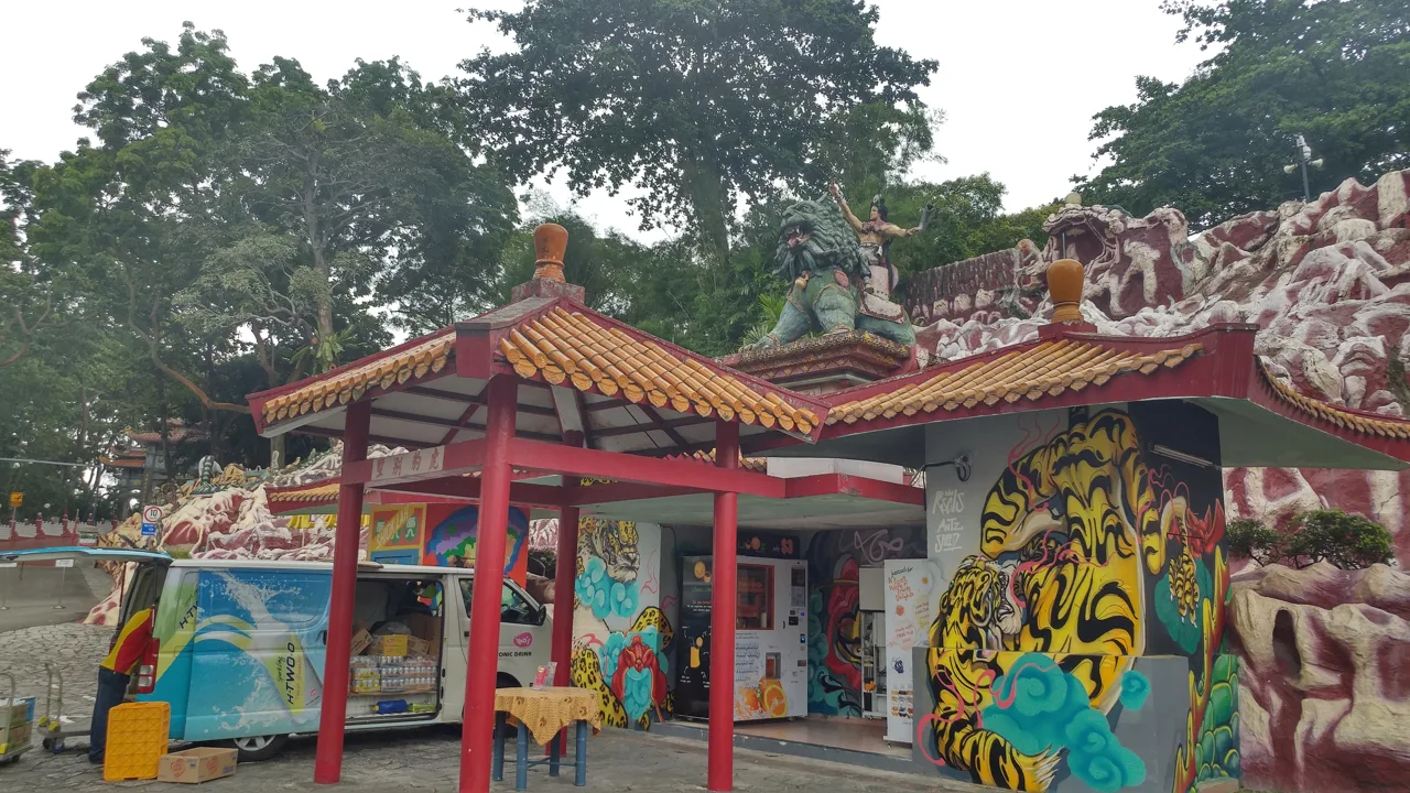 The refreshment kiosk at Haw Par Villa, painted with tigers, in front of the sculpted rockwork