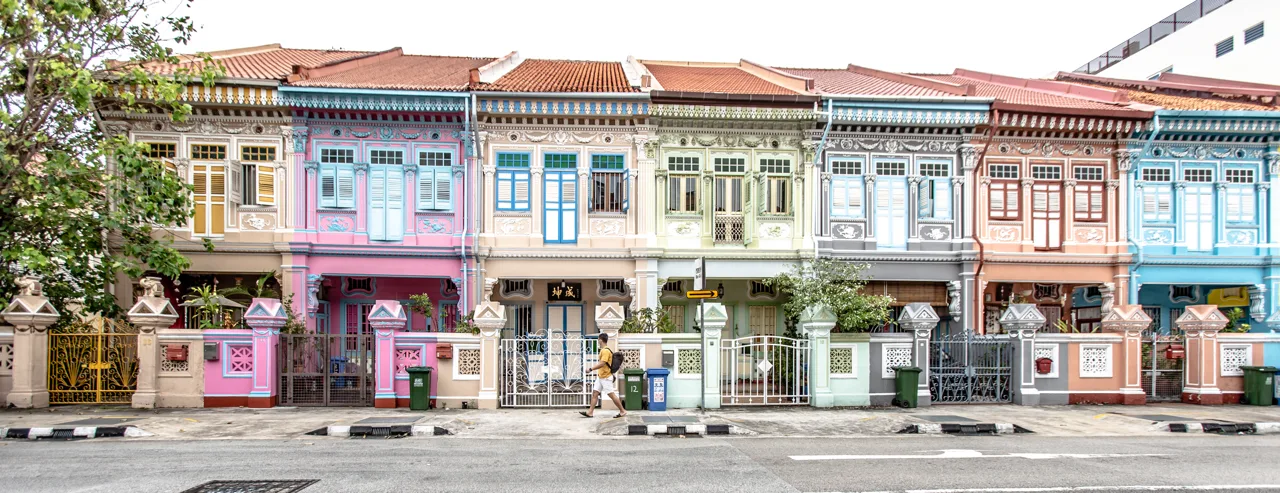 A terrace of pastel Peranakan shophouses in Joo Chiat with tiled walls, shuttered windows and low gates A terrace of pastel Peranakan shophouses in Joo Chiat with tiled walls, shuttered windows and low gates