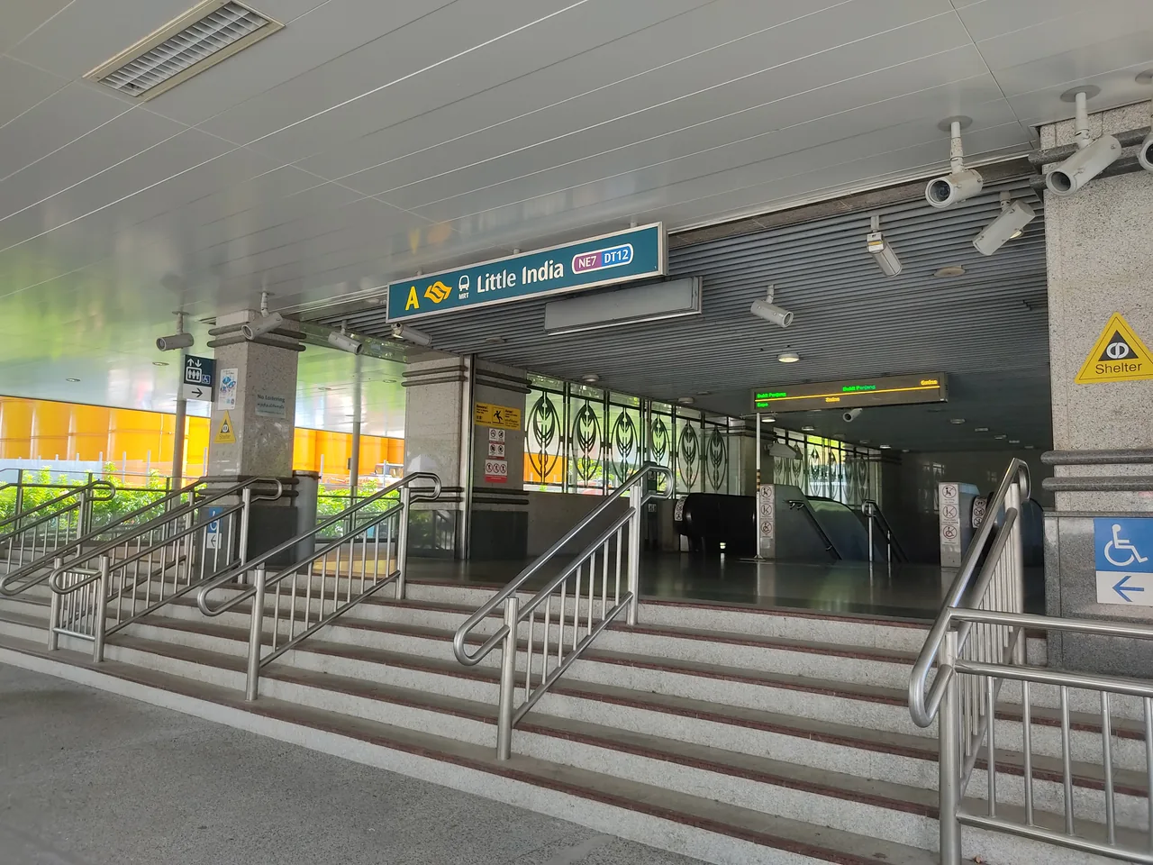 小印度地铁站 A 出口，蓝色指示牌上同时写着 NE7 与 DT12