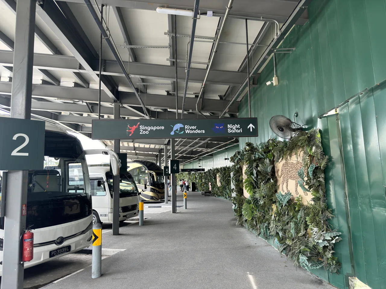 Bus bay 2 at Mandai Wildlife Reserve with a shuttle coach parked under signs for Singapore Zoo, River Wonders and Night Safari