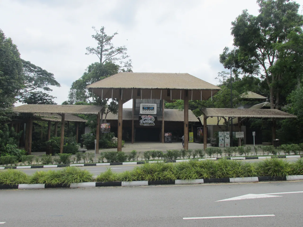 The low timber-roofed entrance building of Night Safari seen from across the road
