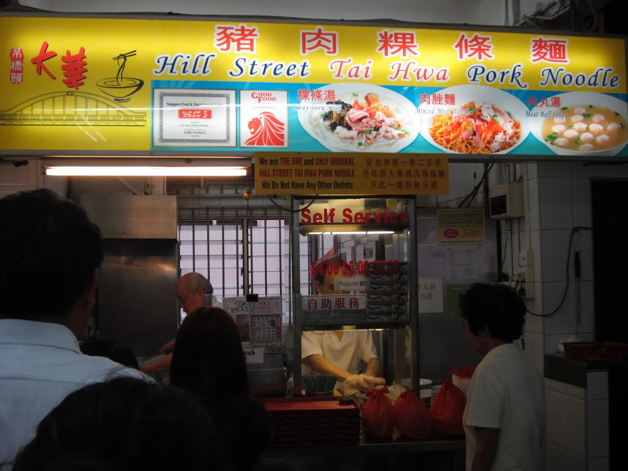 Customers queueing at the Hill Street Tai Hwa Pork Noodle stall beneath its yellow signboard