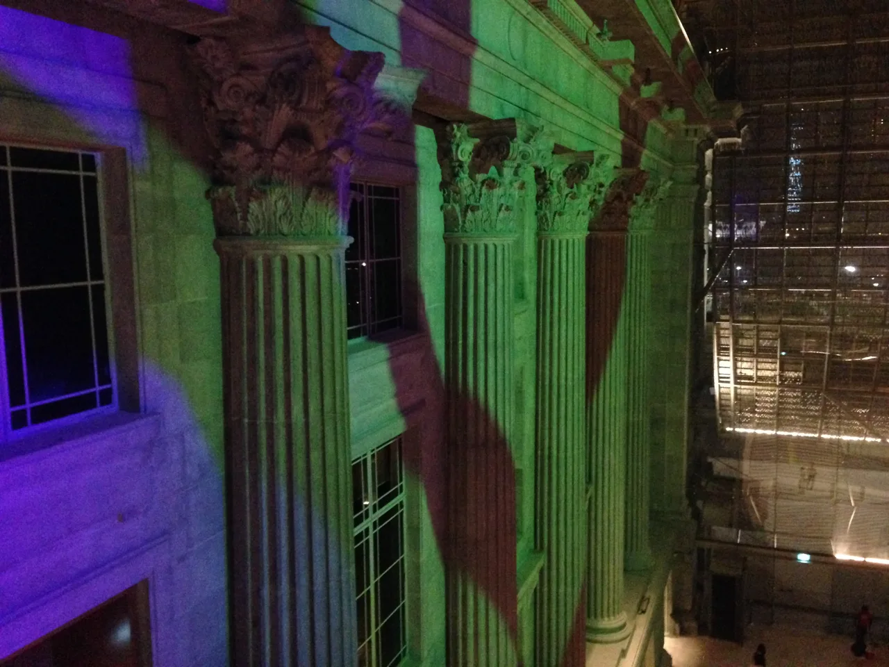 Corinthian capitals on the former City Hall columns lit green and violet for an evening event