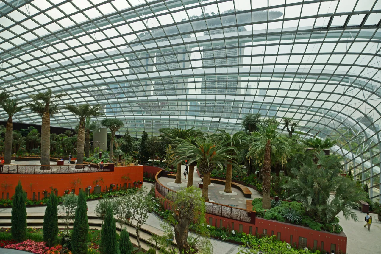 Visitors at the foot of the indoor waterfall in the Cloud Forest, with walkways circling the planted tower above them