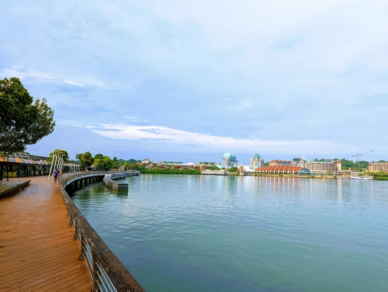 The timber deck of the Sentosa Boardwalk curving over the water towards the island