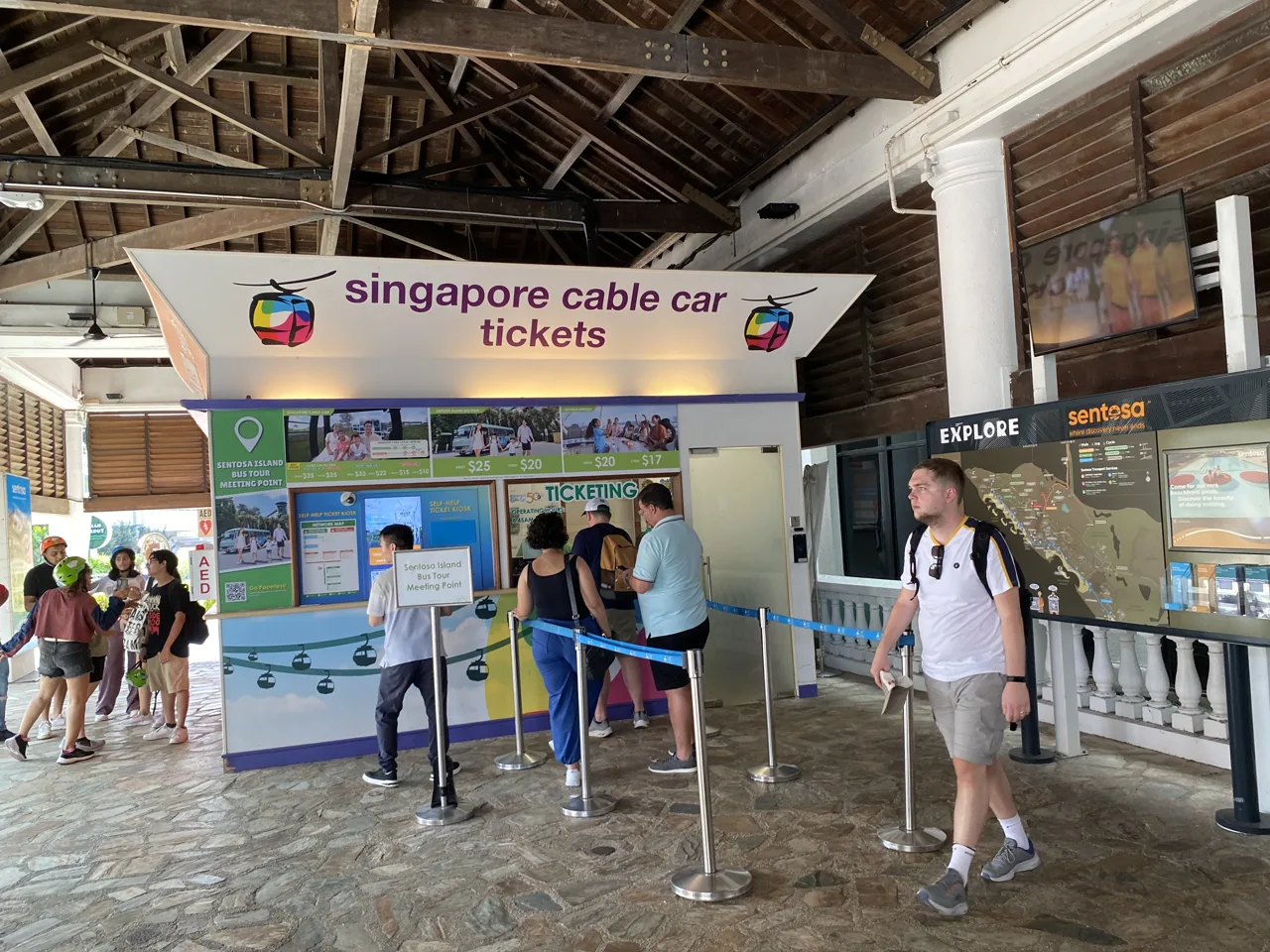The Singapore Cable Car ticket counter at Sentosa station with visitors queueing at the roped lanes