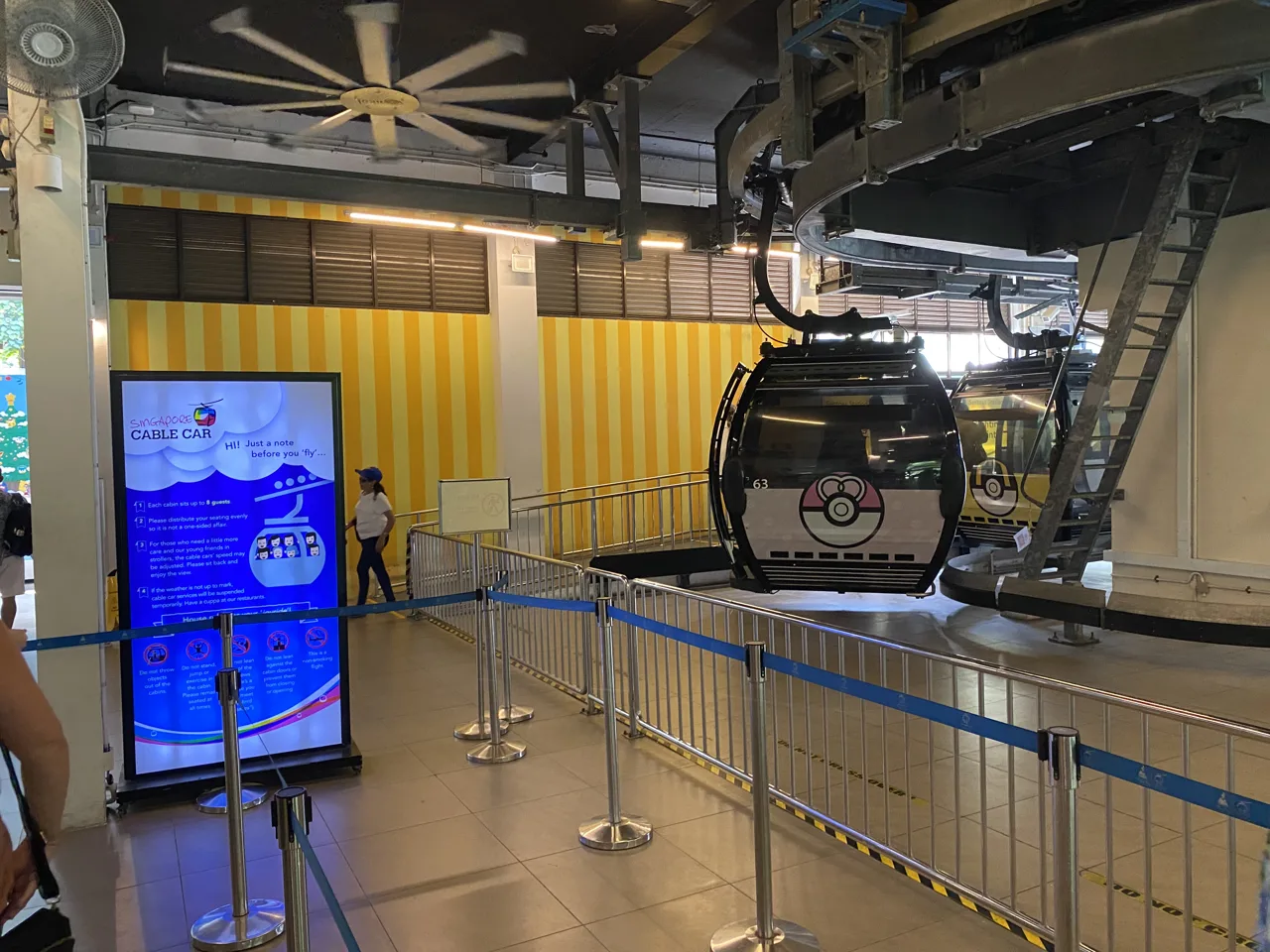 A decorated Singapore Cable Car cabin waiting at the boarding platform inside the station