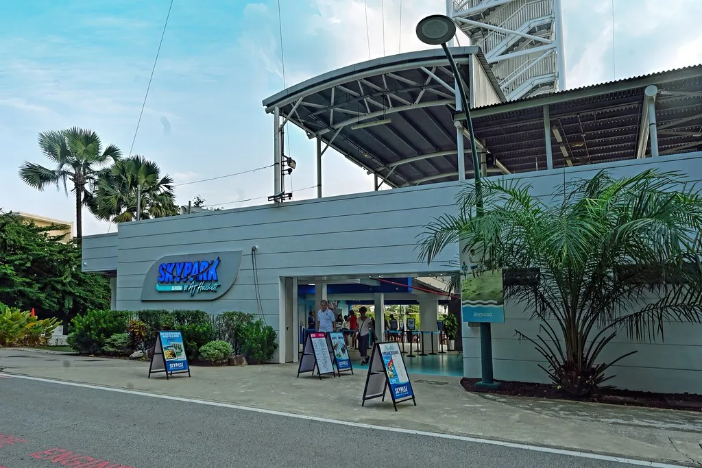 The signed entrance to Skypark Sentosa by AJ Hackett on Siloso Beach Walk, with the tower rising behind it