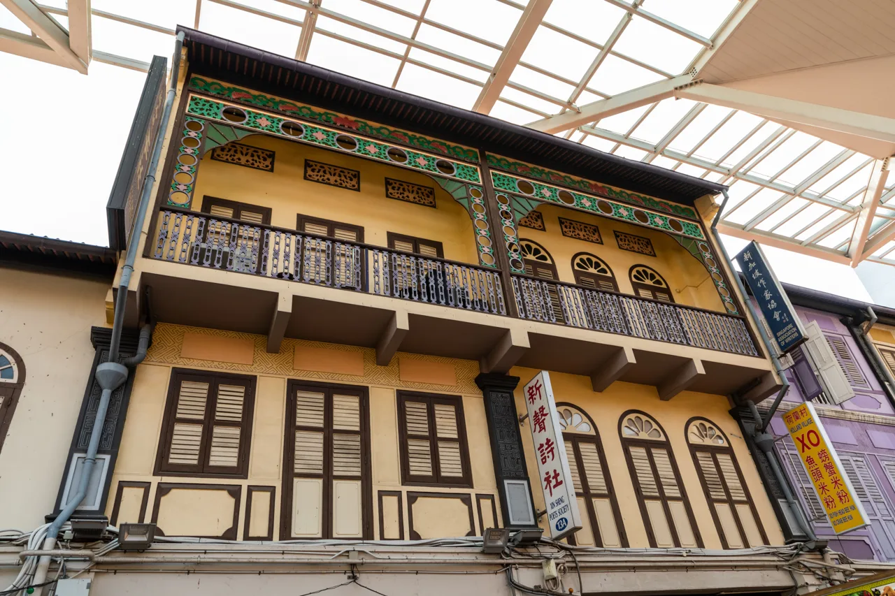 A restored two storey shophouse on Smith Street in Chinatown, with green and gold trim and shuttered windows