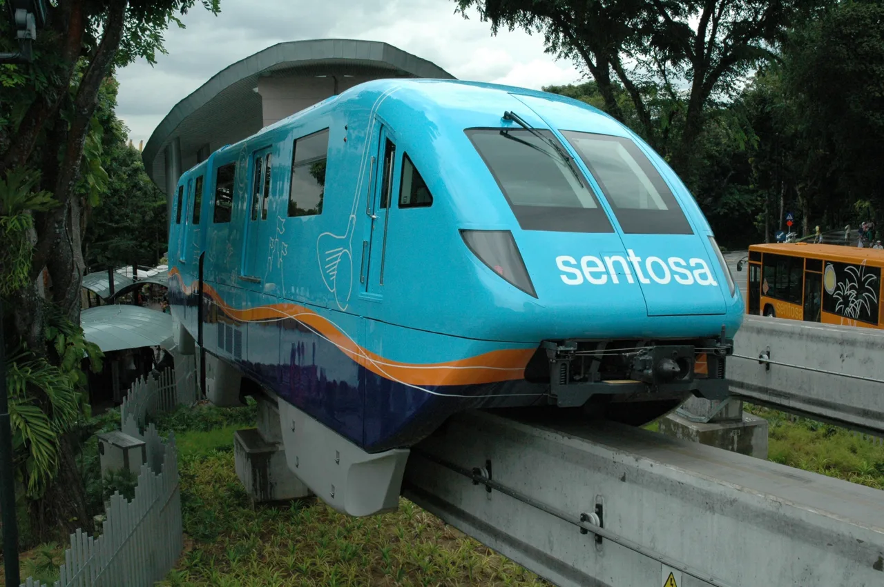 A blue Sentosa Express monorail car pulling into a station on Sentosa