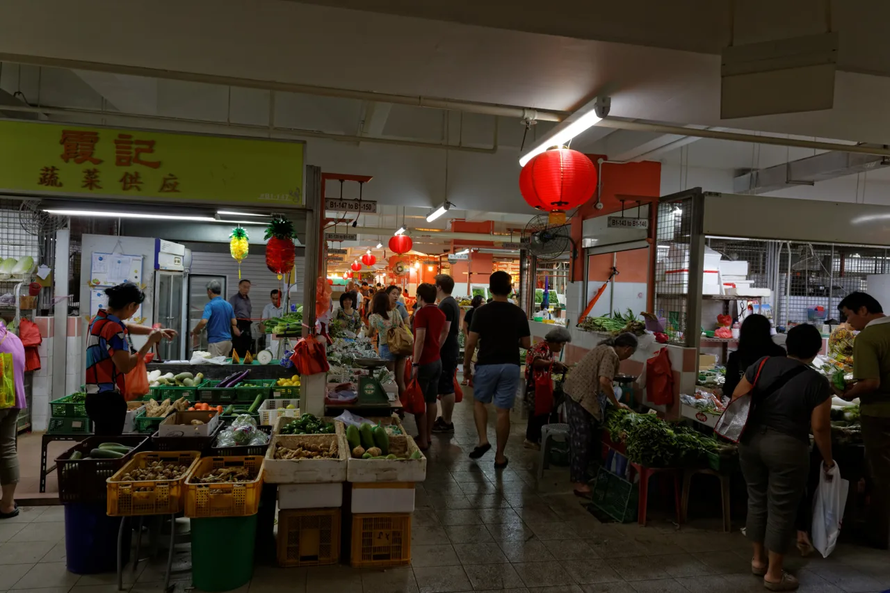 Vegetable stalls and shoppers carrying plastic bags on the market level of Chinatown Complex Vegetable stalls and shoppers carrying plastic bags on the market level of Chinatown Complex