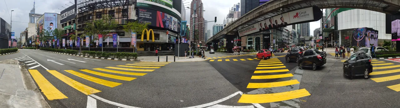 The wide crossing at Bukit Bintang, shops on both sides and the monorail viaduct overhead