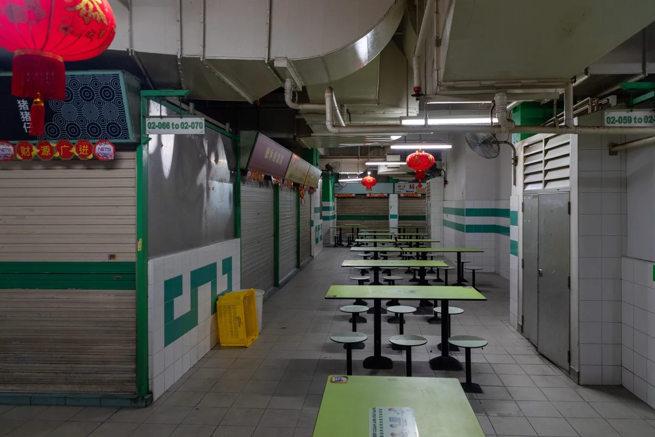 Lorong pusat jajanan lantai 2 Chinatown Complex dengan semua kios tertutup dan meja kosong