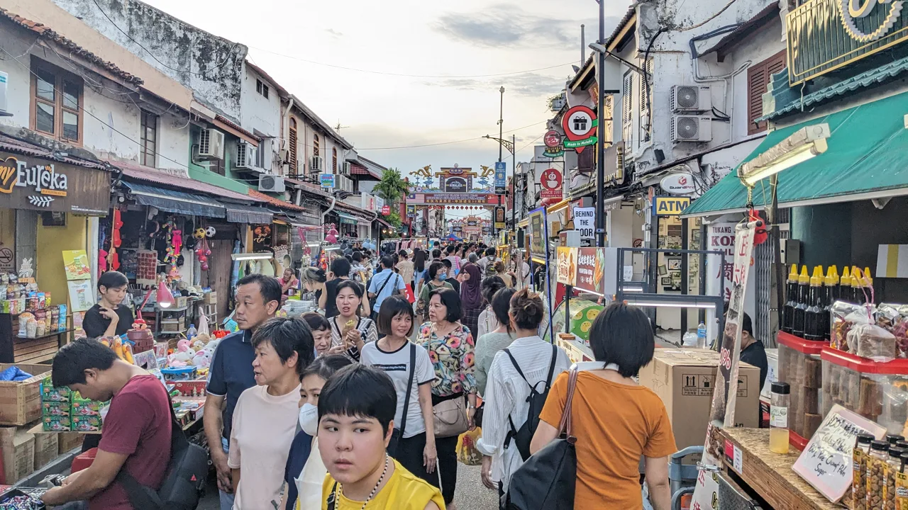 Jonker Street at dusk, narrow and packed with food stalls and people on both sides