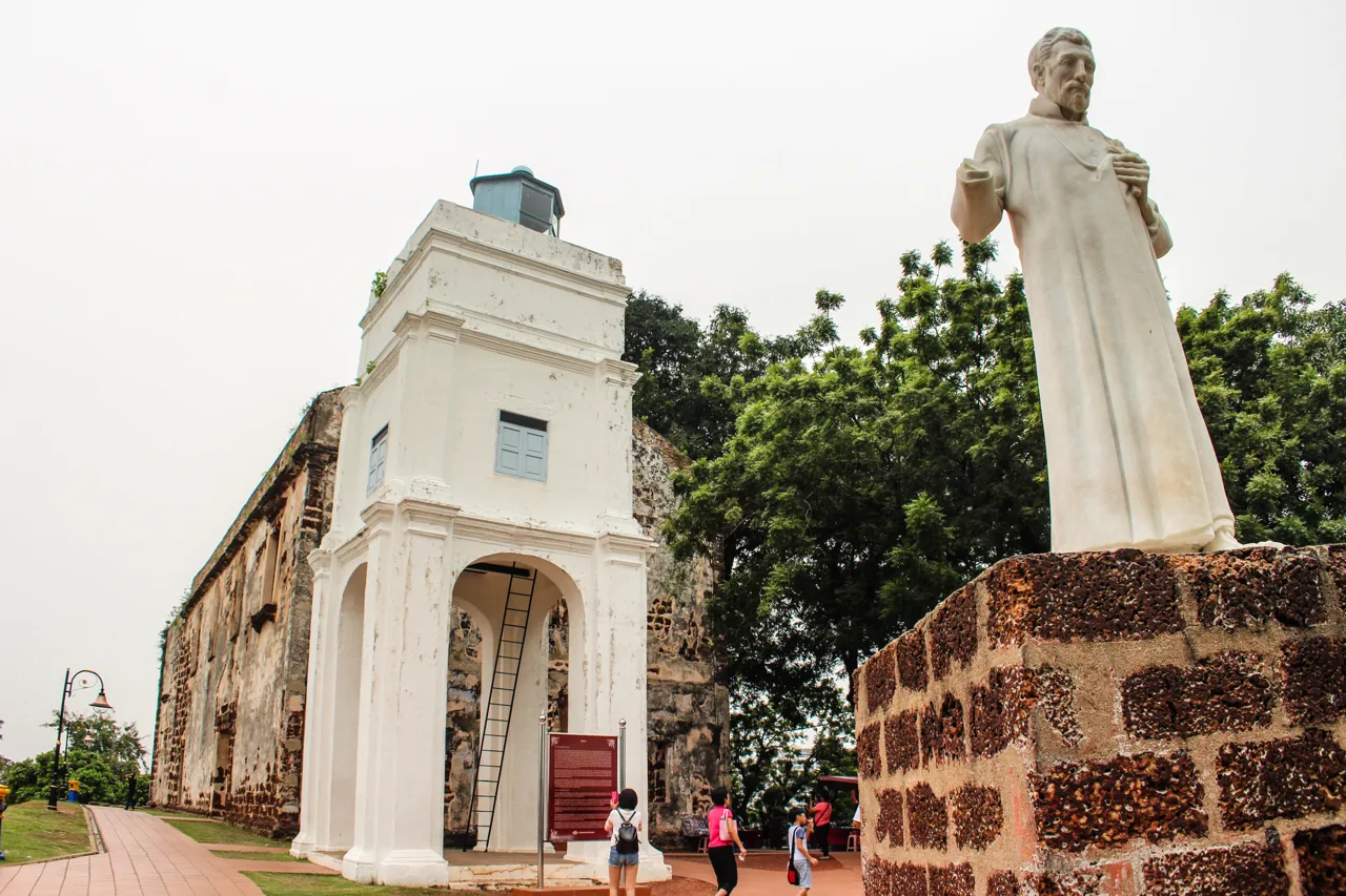 The roofless stone ruin of St Paul's Church on the hill in Melaka, with its white tower and the statue of St Francis Xavier in front