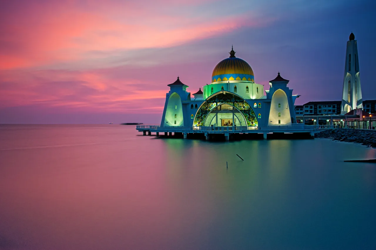 The Melaka Straits Mosque standing on the water at sunset