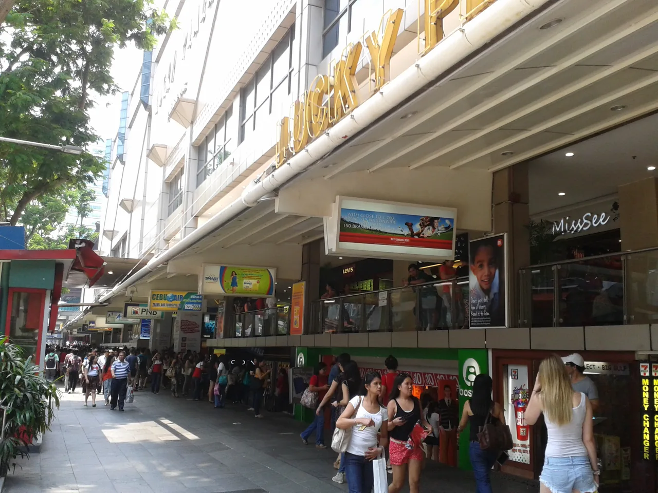 The facade of Lucky Plaza on Orchard Road with people gathered on the pavement outside