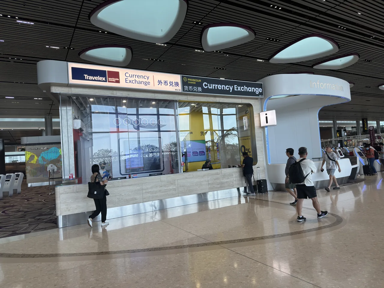 A currency exchange counter at Changi Airport Terminal 4 with a rate board above the window