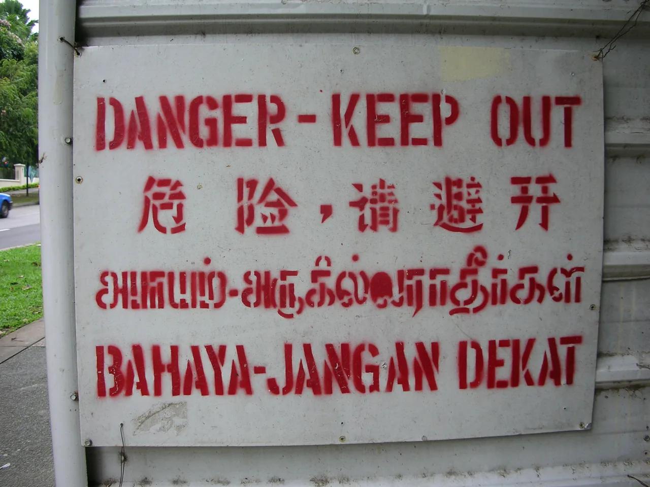 A danger sign in Singapore printed in English, Chinese, Malay and Tamil on the same board